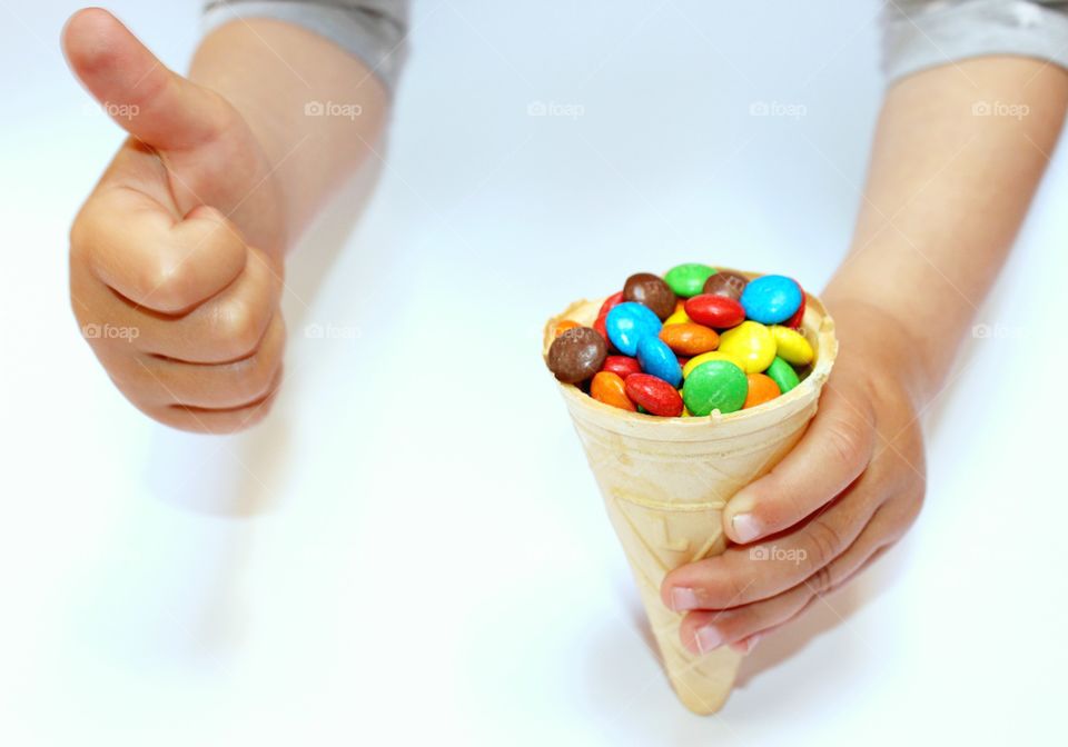 waffle cone with colored dragee in hand