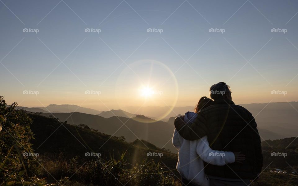 A couple hugging with Sunset background on Pha Tung Hill Chiangrai Thailand
