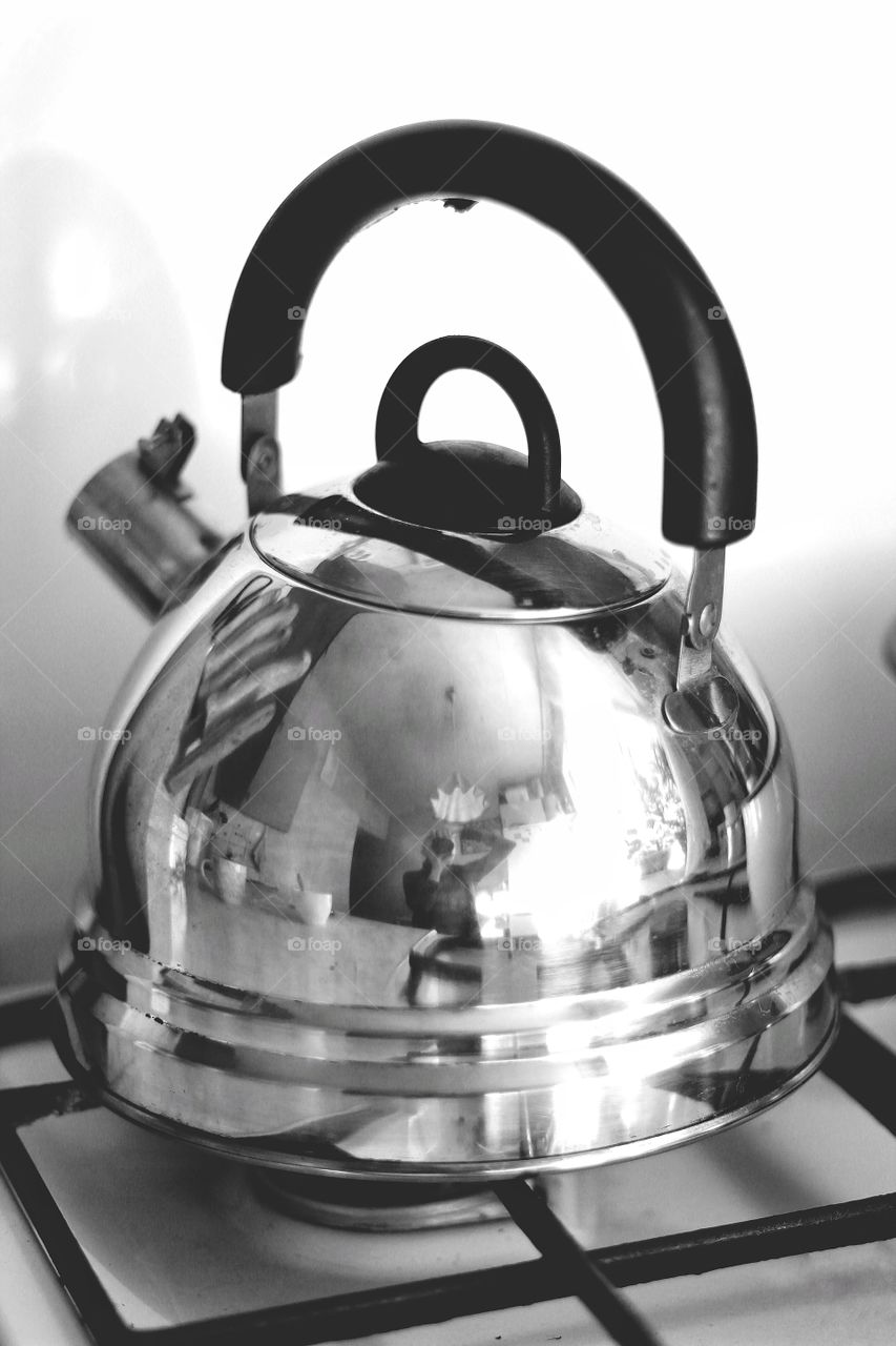 Self portrait of a girl in the kitchen in the reflection of a tea kettle on the stove