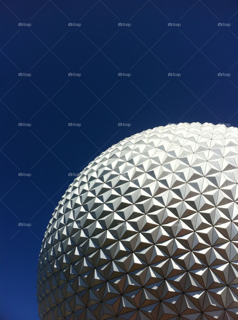 Spaceship Earth in front of clear blue sky at Epcot within the Walt Disney World Resort.