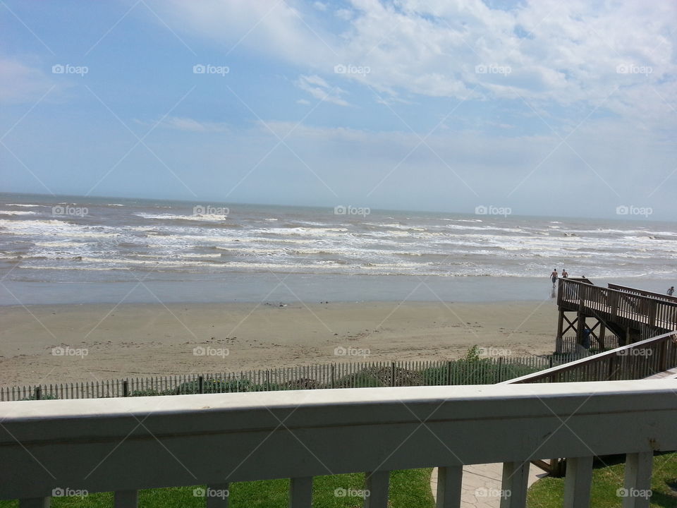 Beach front view in Galveston, Texas. Beautiful waves meet the sand in this photo.