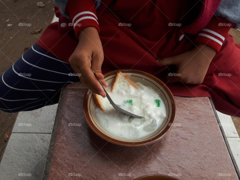 green banana ice, which consists of a variety of marrow porridge, pudding, ice cubes, plain bread, nuts, bananas cut into small pieces, is a delicious and cheap drink in Indonesia.
