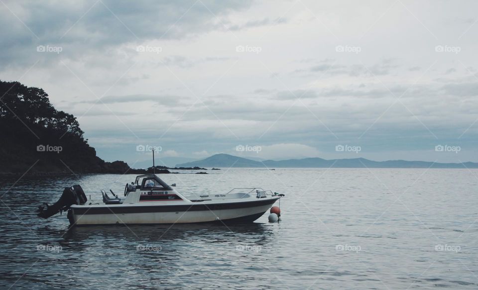 lonely small boat on a seaside, cloudy evening