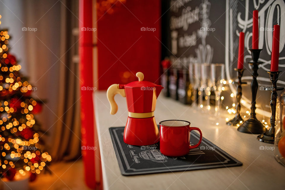 Festive winter cozy kitchen interior with garlands, decorations and gifts.  Christmas dinner at the decorated table.