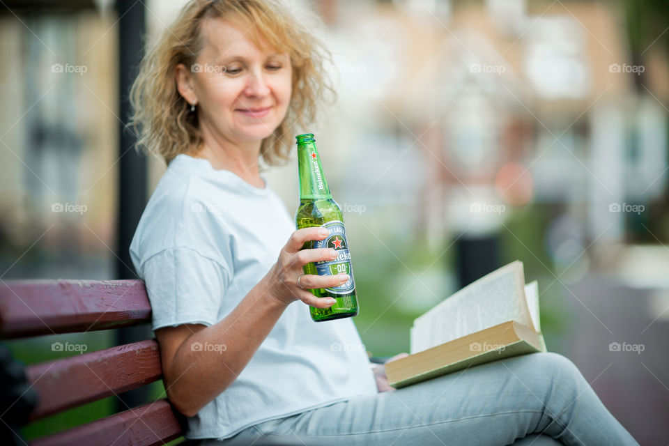  Woman in city with bottle of nonalcoholic Heineken beer 