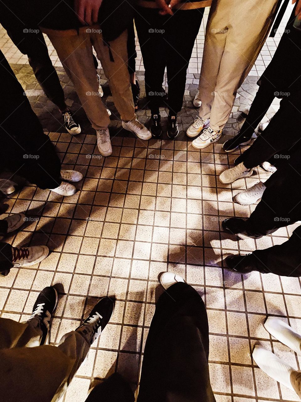 Legs and shoes of a team of people standing in a circle