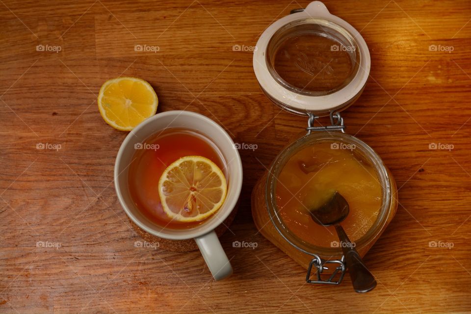 Tea with lemon next to honey jar