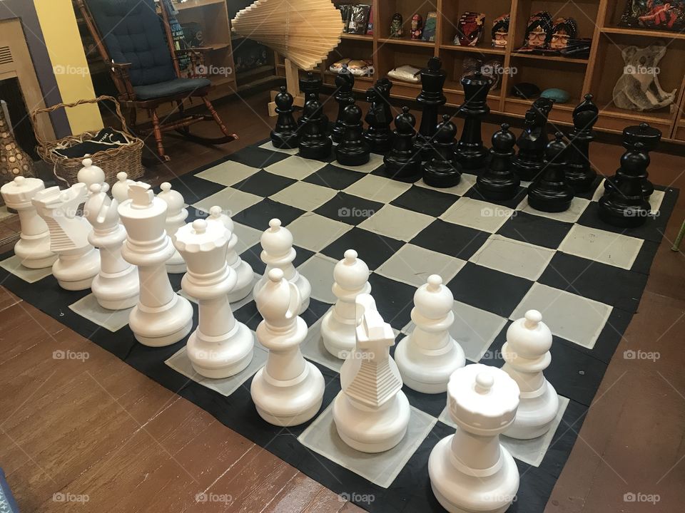 Giant chess in a quiet coffee shop. A bit different than the out doors setup. Looking for the right first move.
