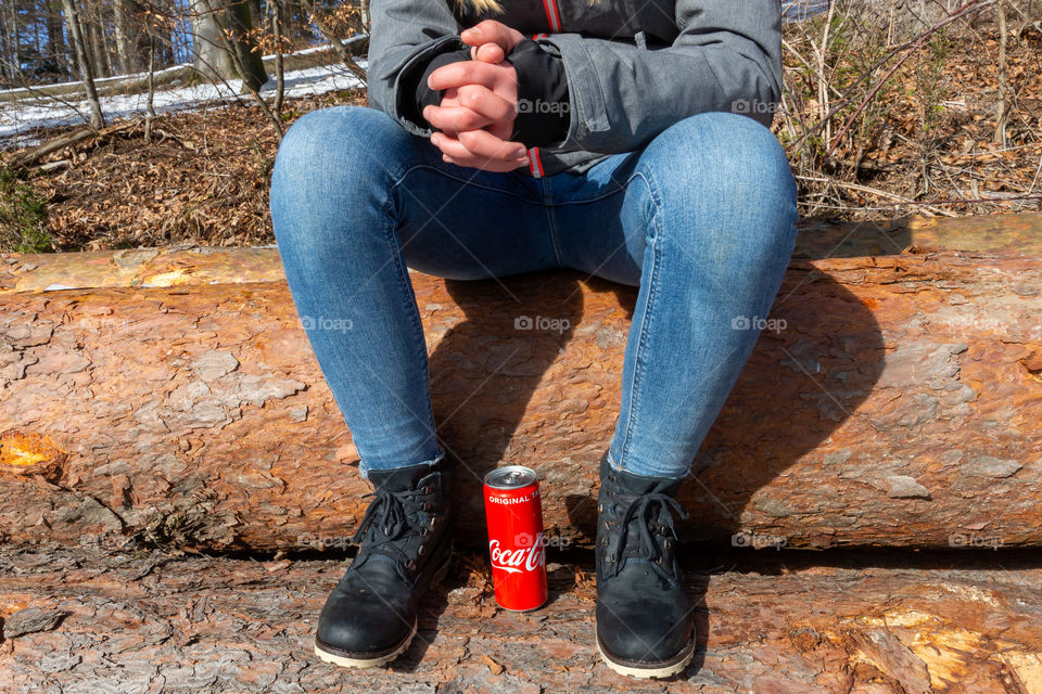 legs of a girl and a Coca Cola tin