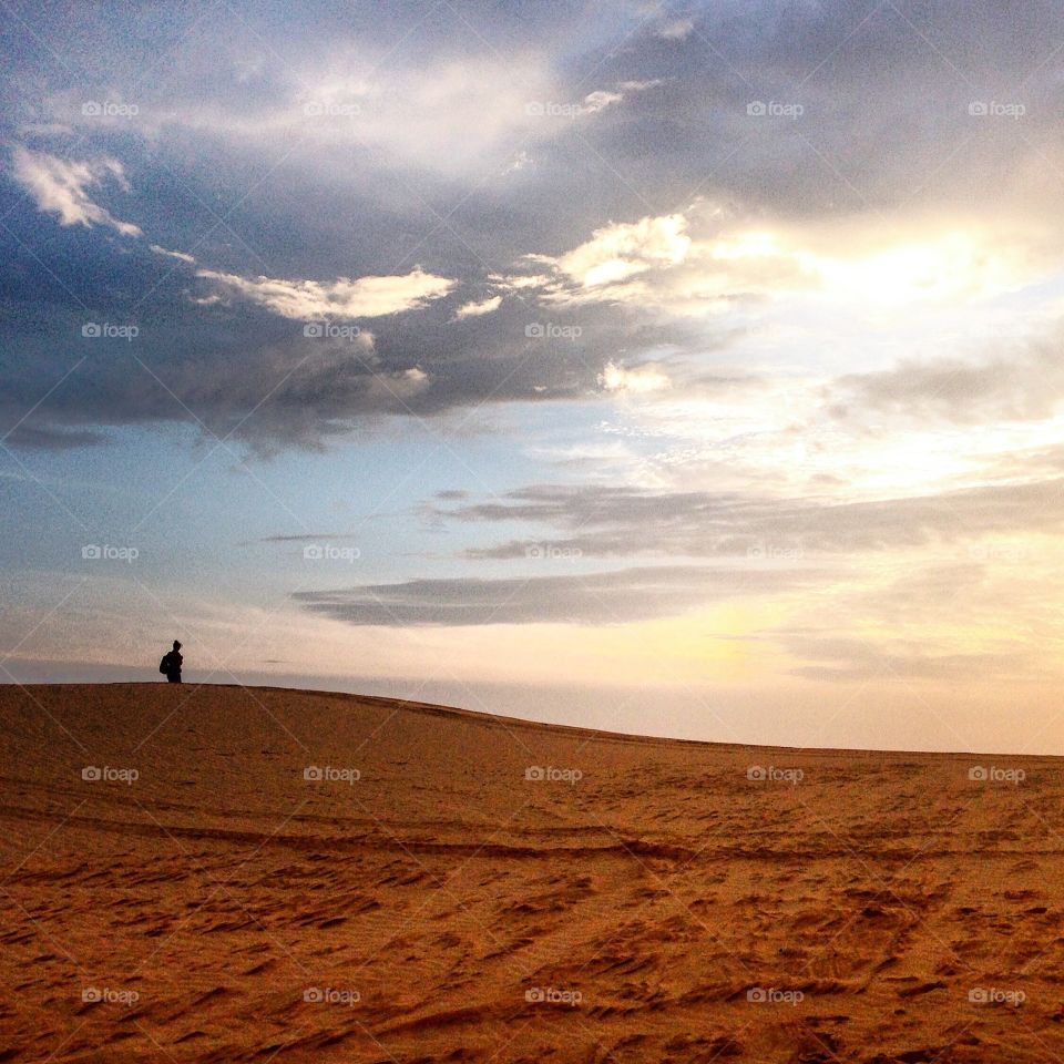 Top of the world. A man walkingnon the top of dunes in Mui Ne, Vietnam