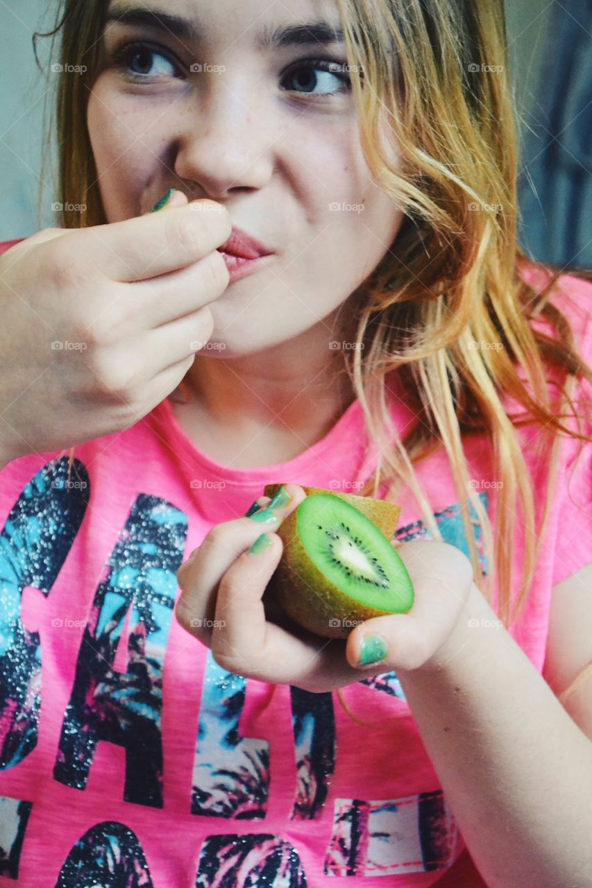 Girl eating kiwi