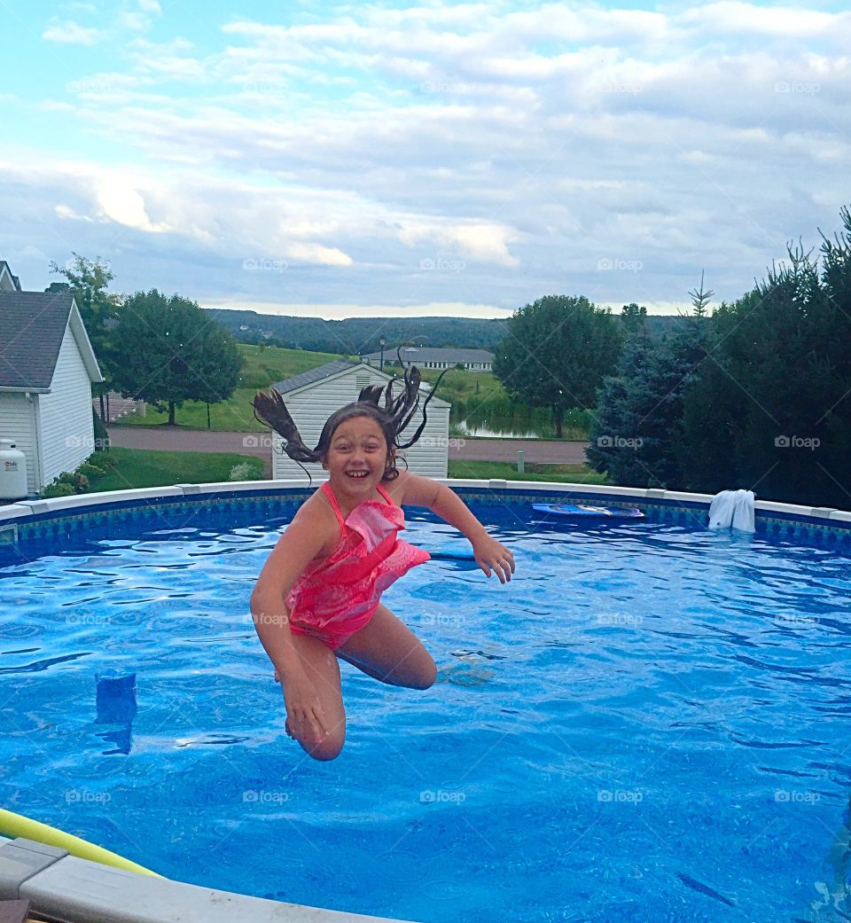 Little girl jumping in the swimming pool