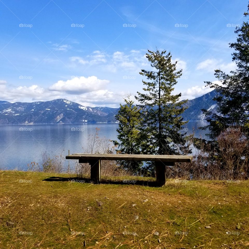 wooden bench with a view of lake and mountain ridge
