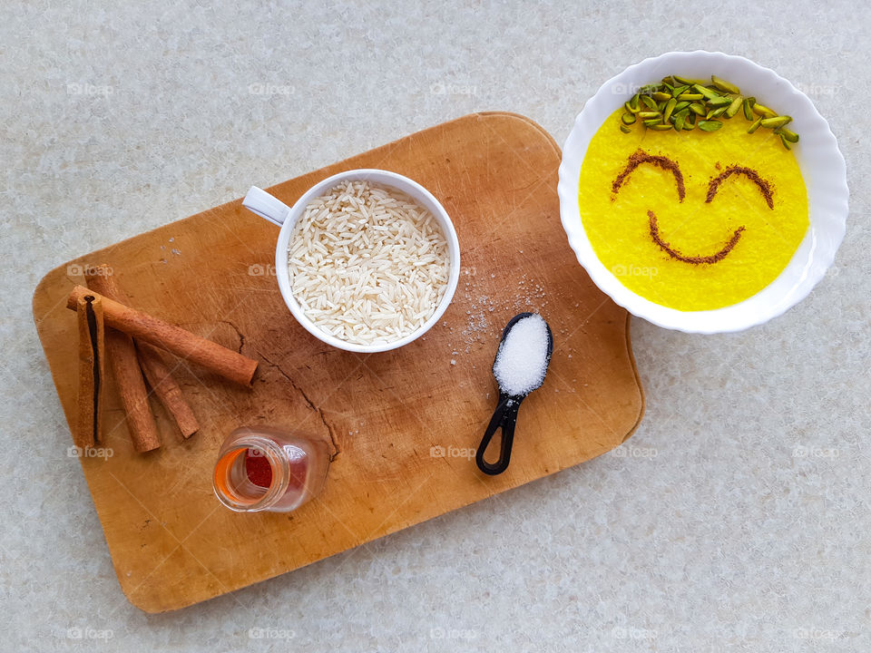 creating a delicious happy little dessert. sholezard, with the ingredients sugar, rice, cinnamon, saffron and some pistachios on top. I just love this dessert, decorating the top before eating it, is half the fun