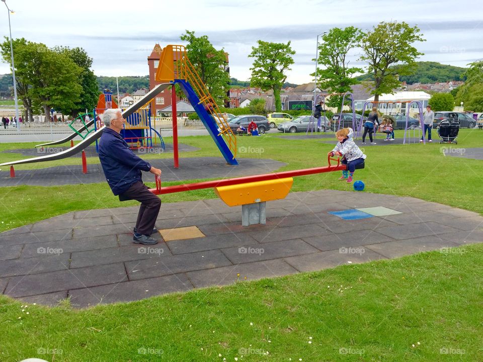 Grandad and granddaughter playing in the park 