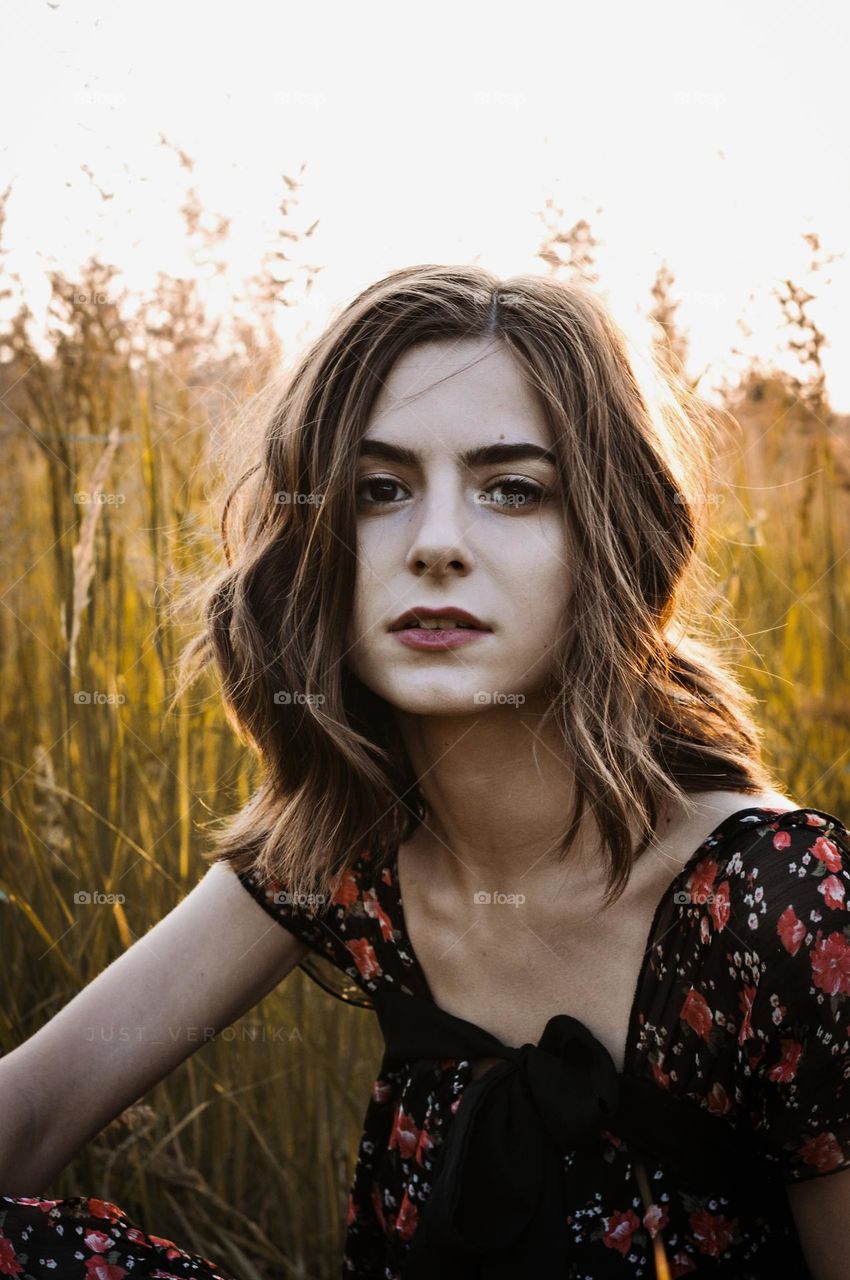 Close-up portrait of a girl. A girl with her hair tied up is caught in the light.