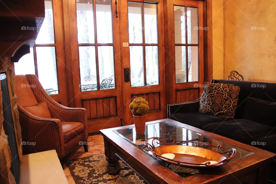 Beautiful living room with wooden doors leading to patio outdoors 