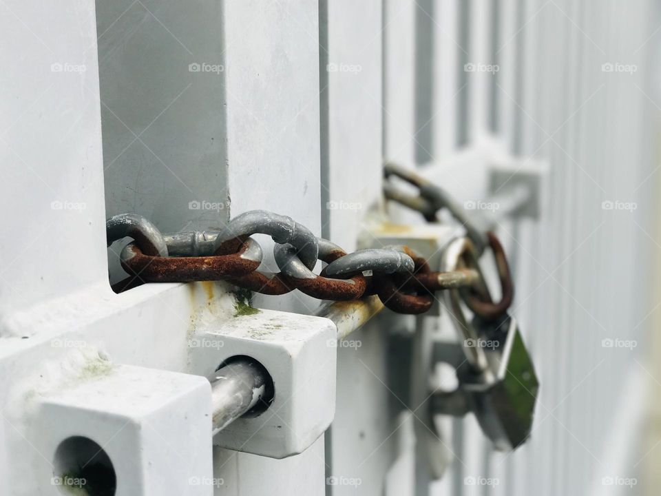 Rusty chain with metal lock to the gate 