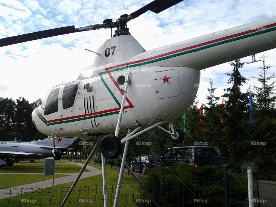 The helicopter is flying against the blue sky.