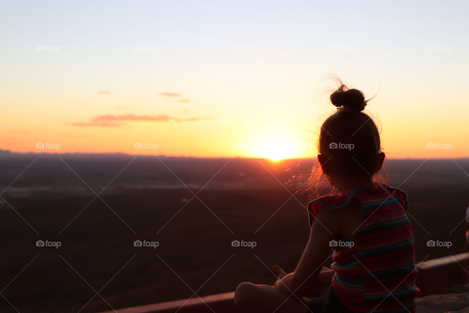 Child watching the sunset over El Paso, Texas