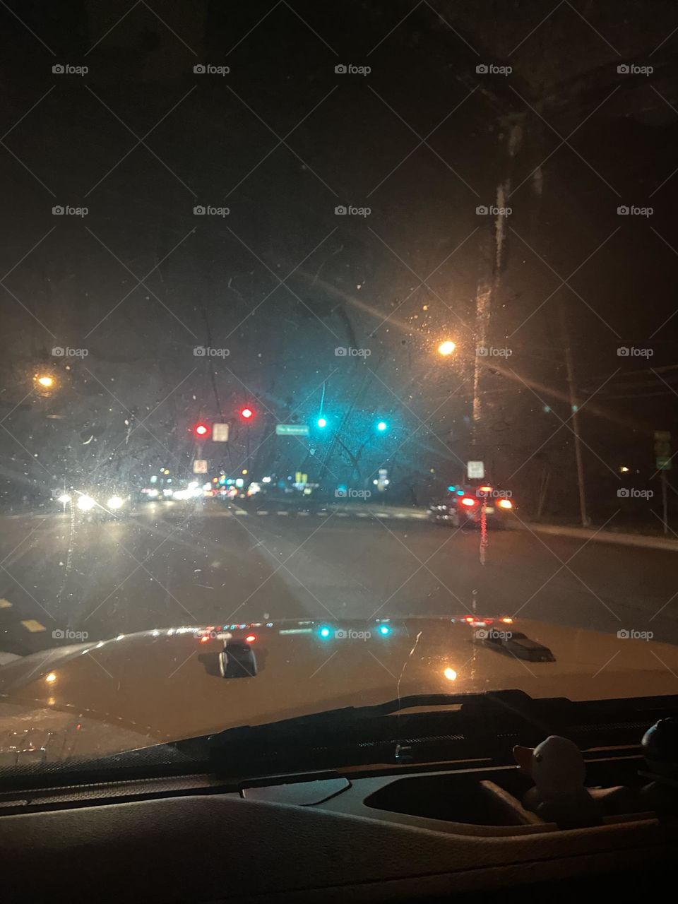 Burnt Tavern Road in Brick, NJ in the early evening. The traffic lights reflect on the top of my Jeep, and others can be seen in the distance. Headlights from cars also light the scene. I took this safely and quickly while stopped at traffic light.