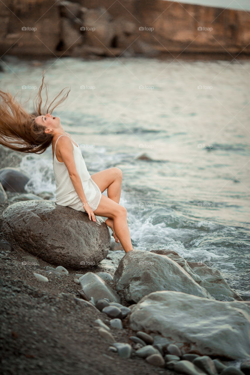 Beautiful young woman on sea coast 