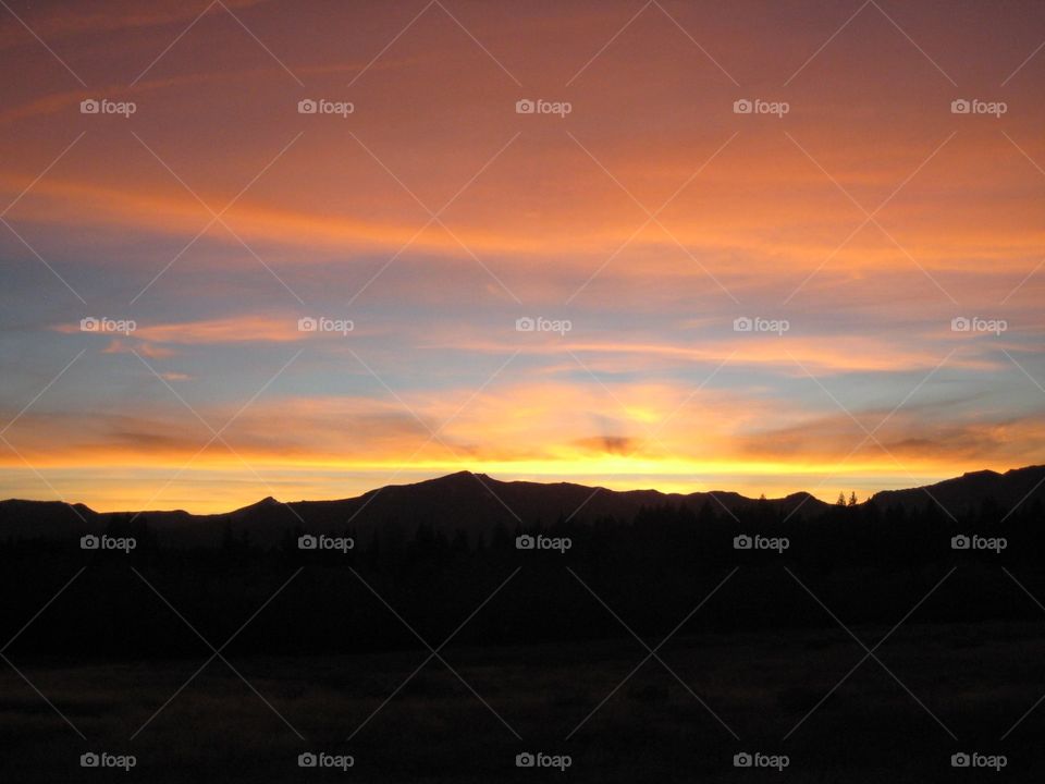 Colorful sunset. Yellow and orange sunset against mountains