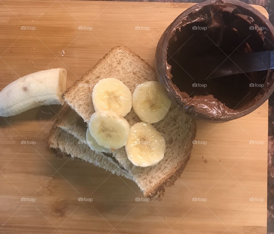 Making a yummy banana and Nutella sandwich for lunch displayed on a cutting board. USA, America 
