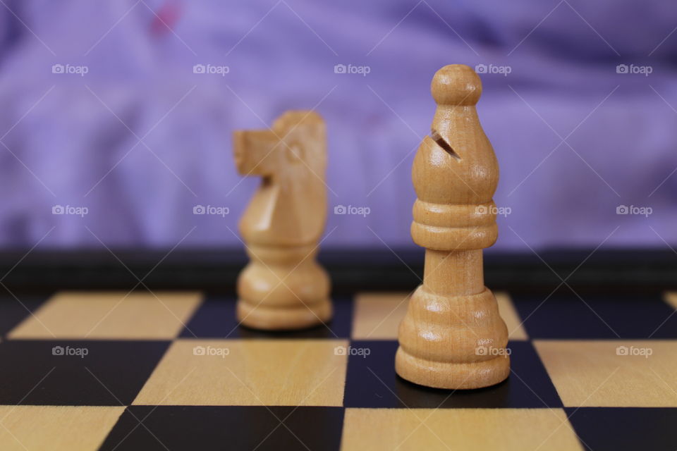 Miniature chess pieces on chess board
