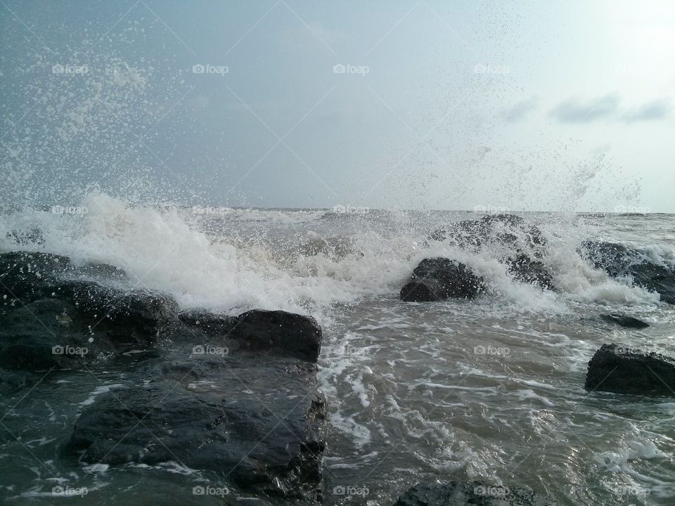 Sea waves crushing to rock