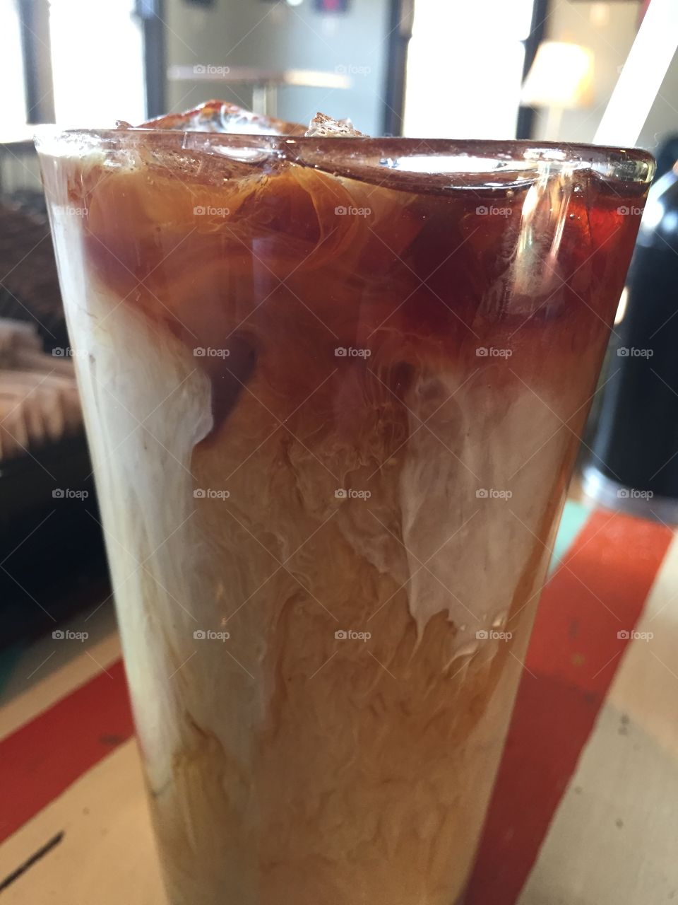 Cream sinking into iced coffee.