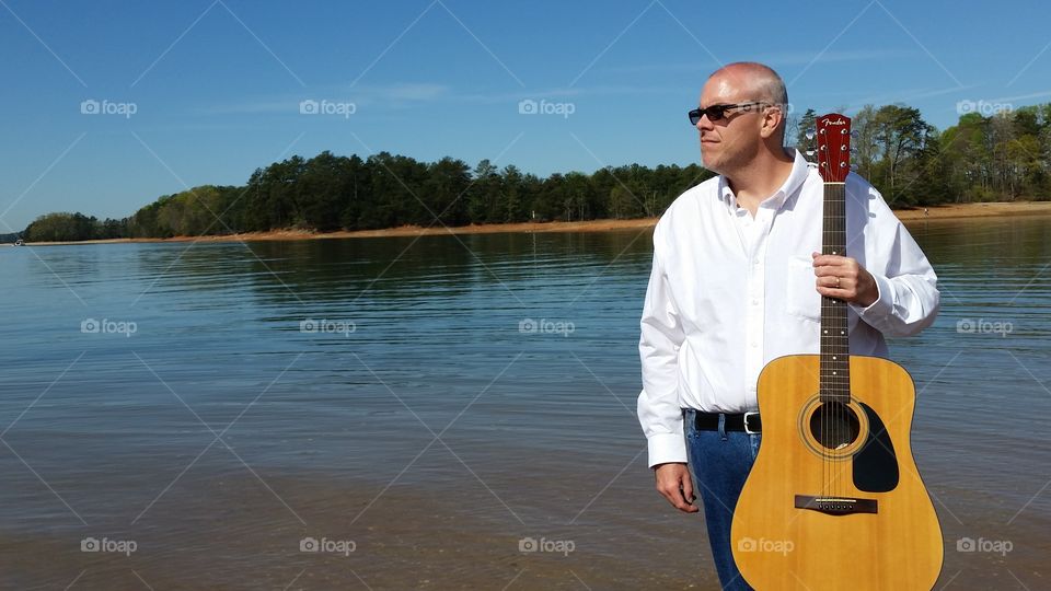 man on lake with guitar