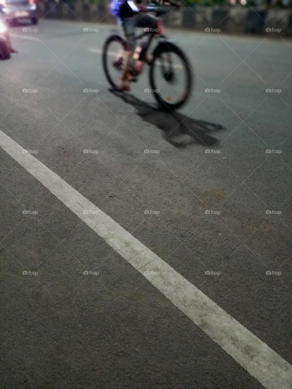 Bicycle riding on street  Night time nice cline rode with beautiful shadow  bycycle and rider white border line on road night journey