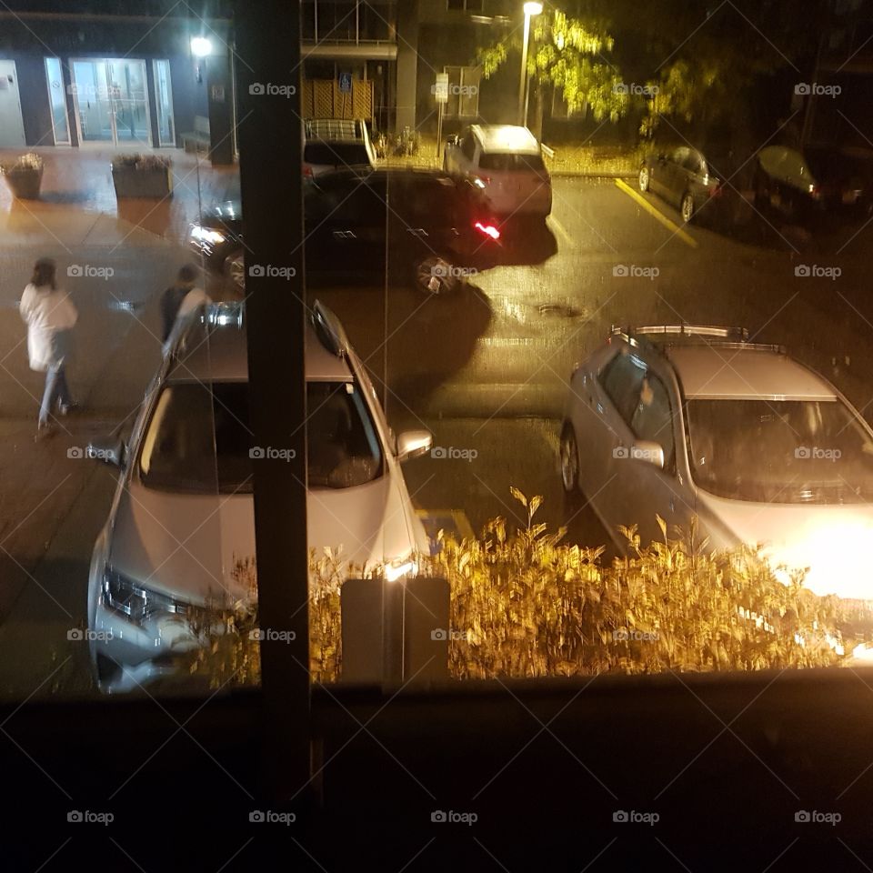 A busy parking lot blanketed in the cool nights rain