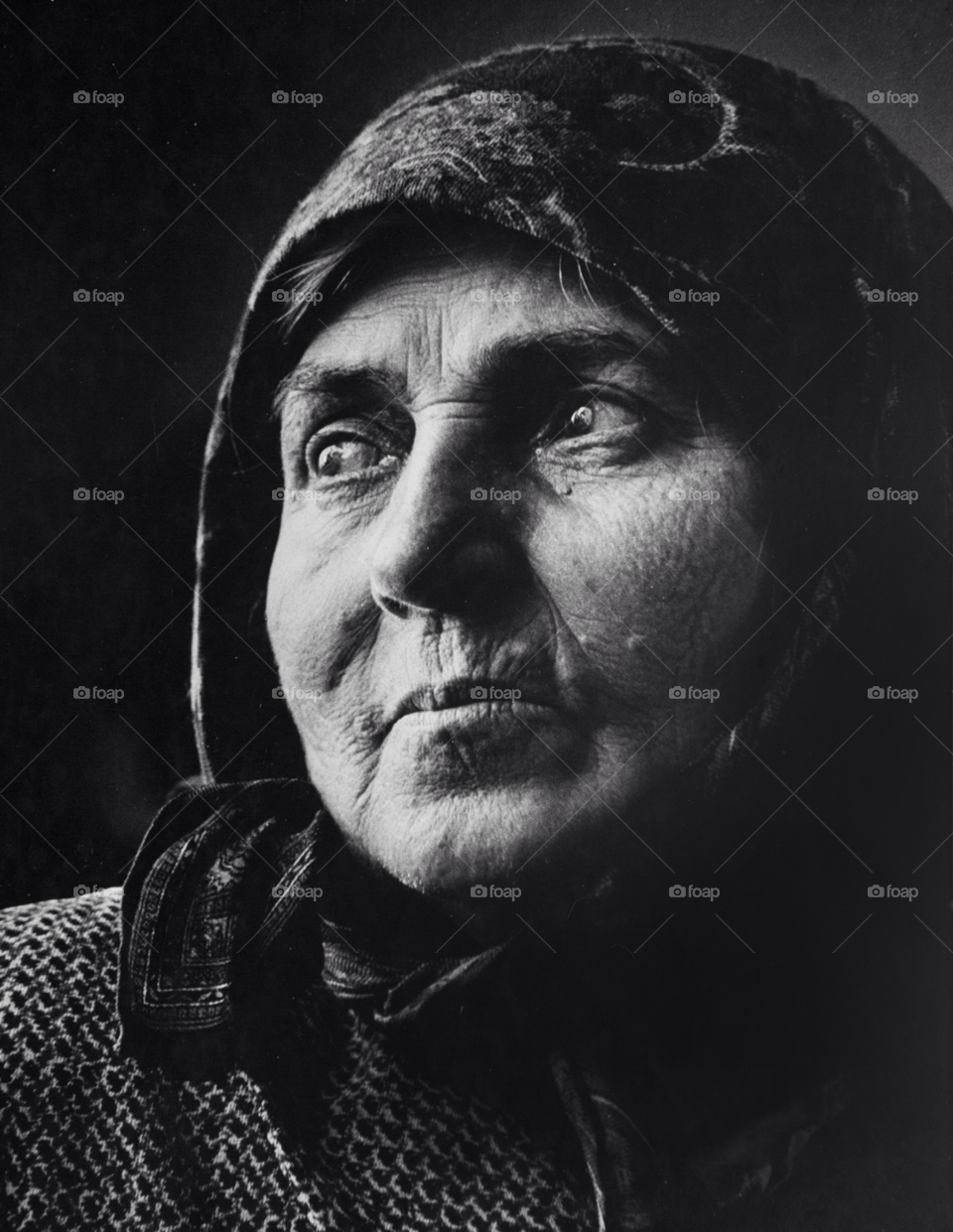 an old romanian woman looks out her window. old woman. by arizphotog