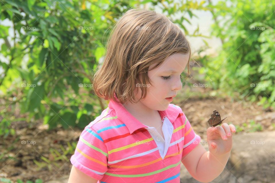 Butterfly on my Finger. Little girl with a butterfly on her finger