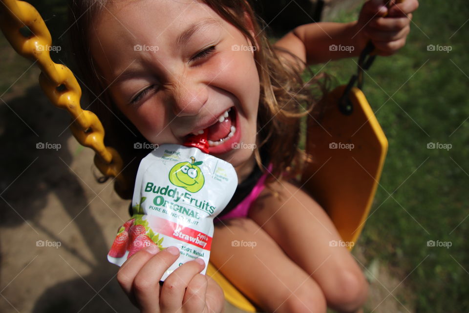 Little girl enjoying buddy fruits outdoors