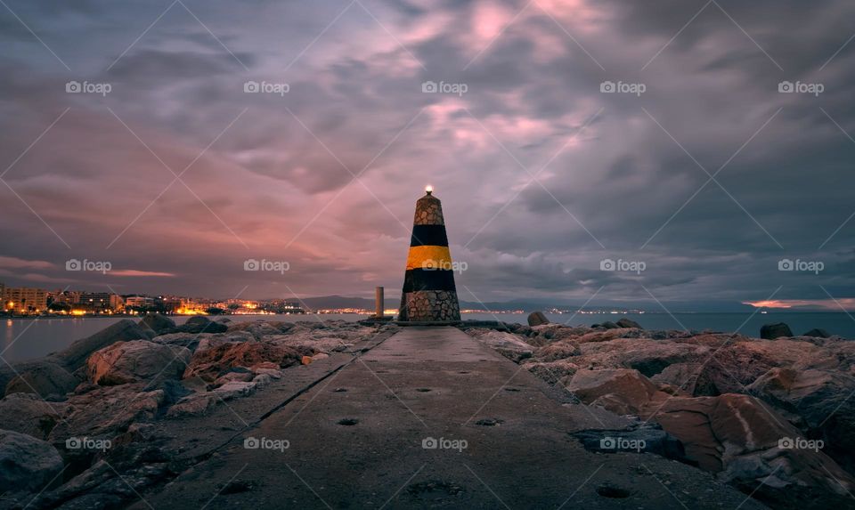 Dramatic cloudy scenery at Faro Levante, lighthouse at Benalmádena, Málaga, Spain