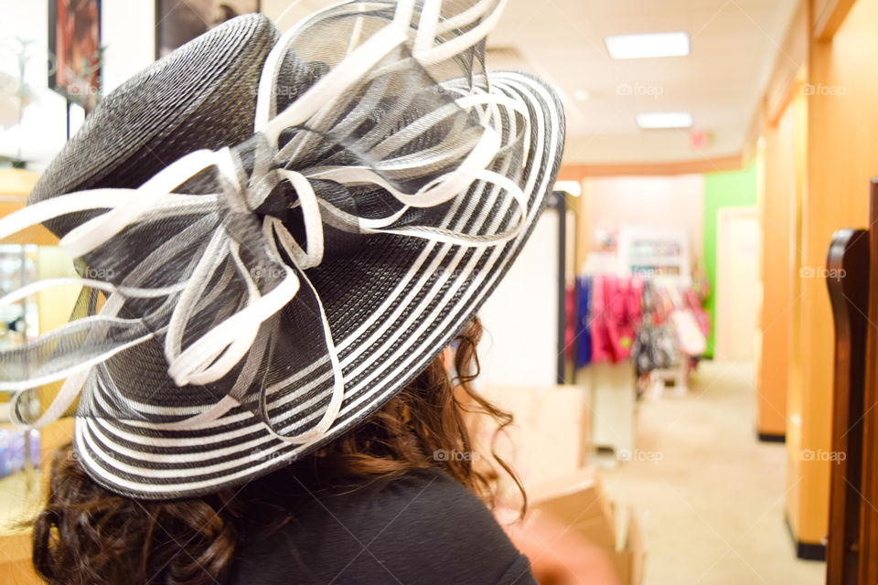 Girl Wearing Hat at Store. Trying a black and white hat at the mall.
