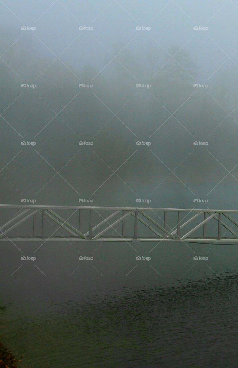 walkway over water in the fog.