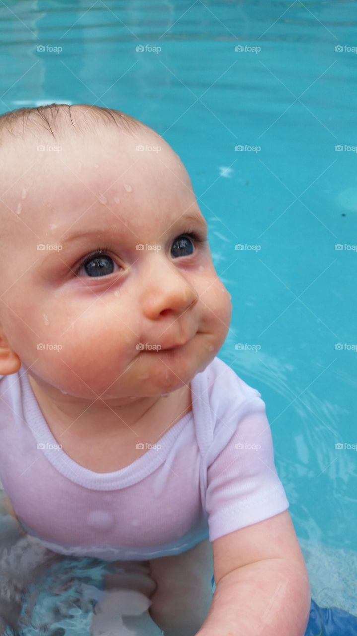 splish splash . baby in the pool for the first time