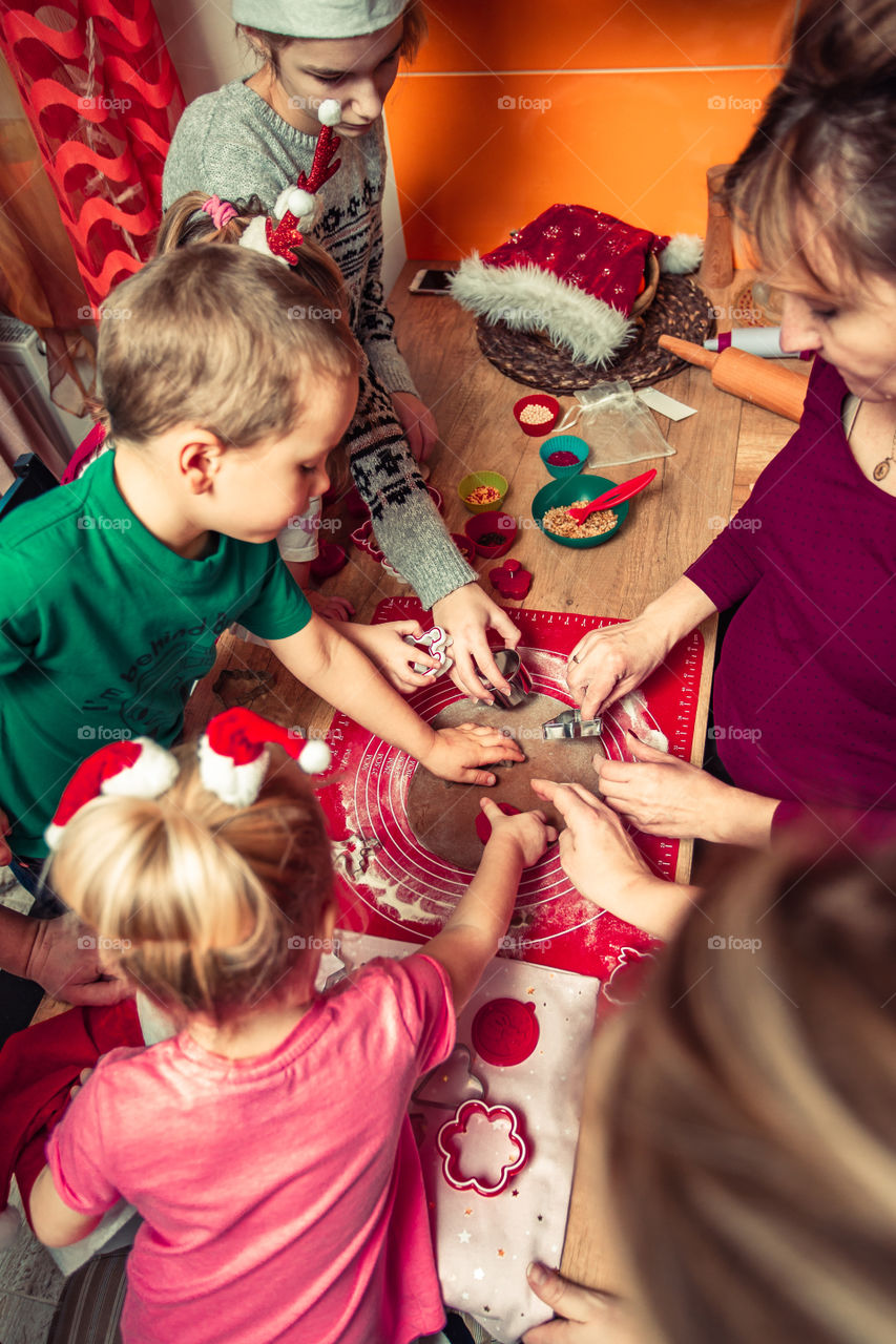Baking Christmas cookies. Christmas gingerbread cookies in many shapes decorated with colorful frosting, sprinkle, icing, chocolate coating, toppers, put on table. Baking traditional cookies. Family celebrating Christmas. Baking at home