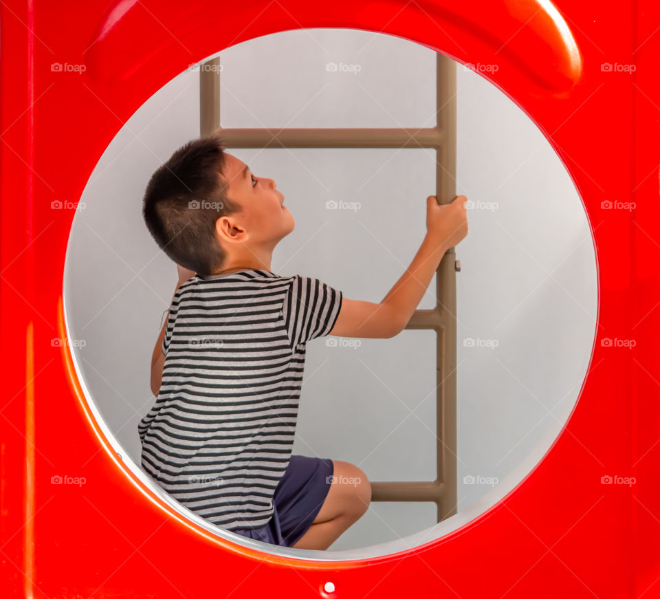 Portrait of Asian boys are climbing the ladder in the playground.