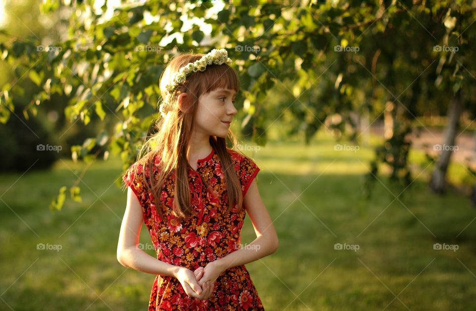 Summer walk in the park of a girl in a wreath of clover
