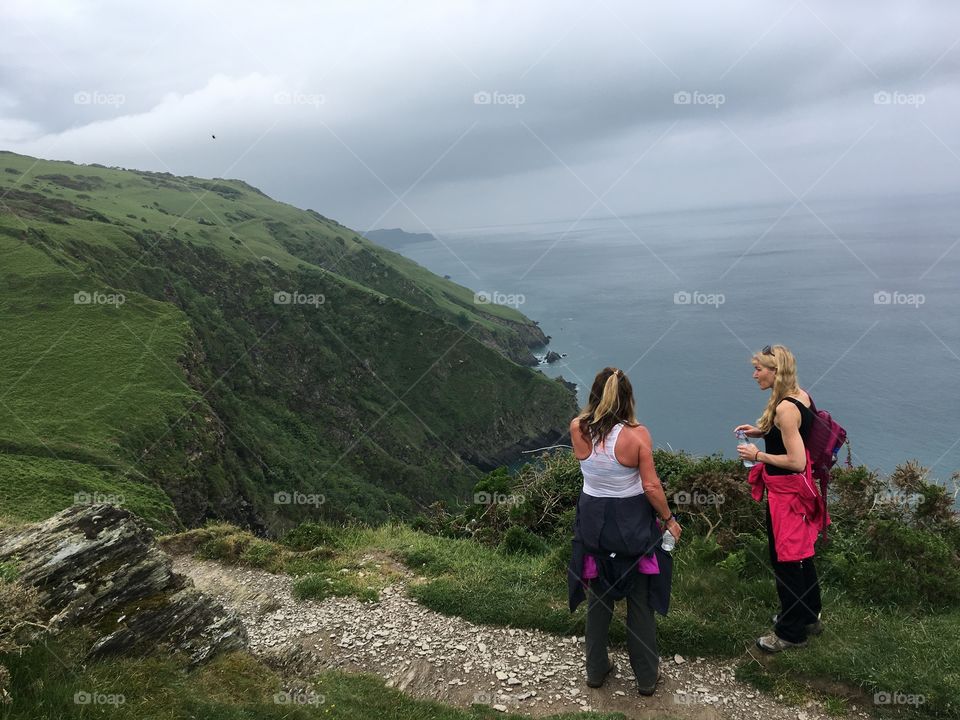 Two ladies on a coastal path in scenic North Devon, in between Ilfracombe and Lee, looking out to sea. 