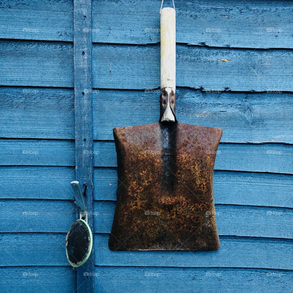 Gardening tools including space against a blue fence  background 