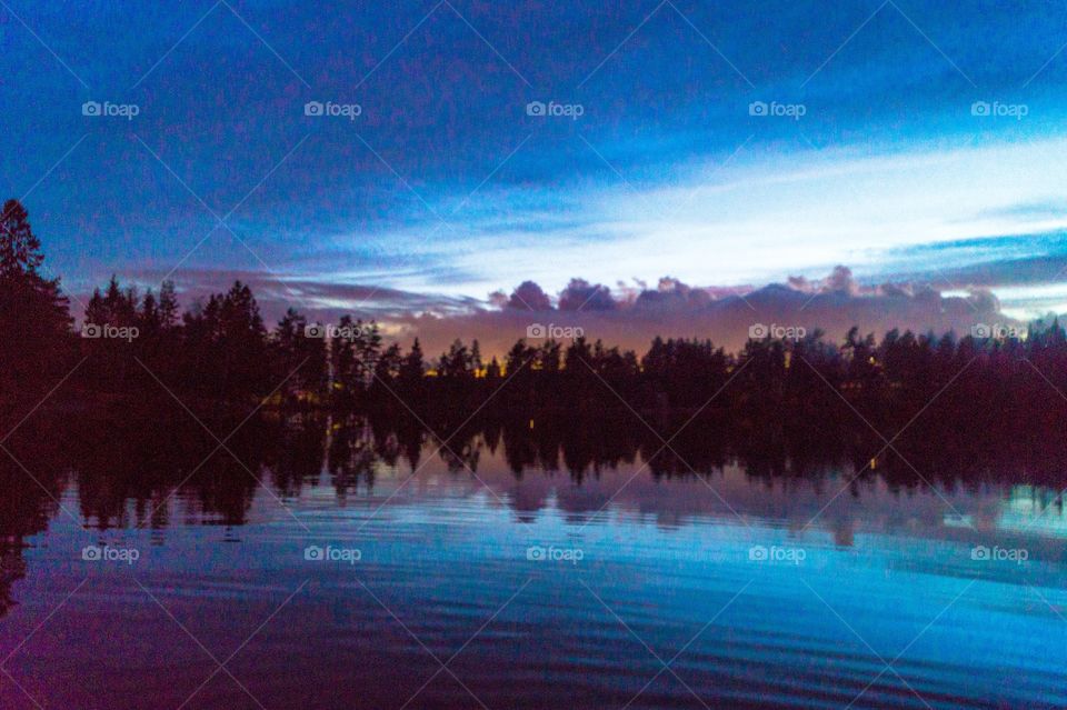 Silhouette of trees reflecting on lake