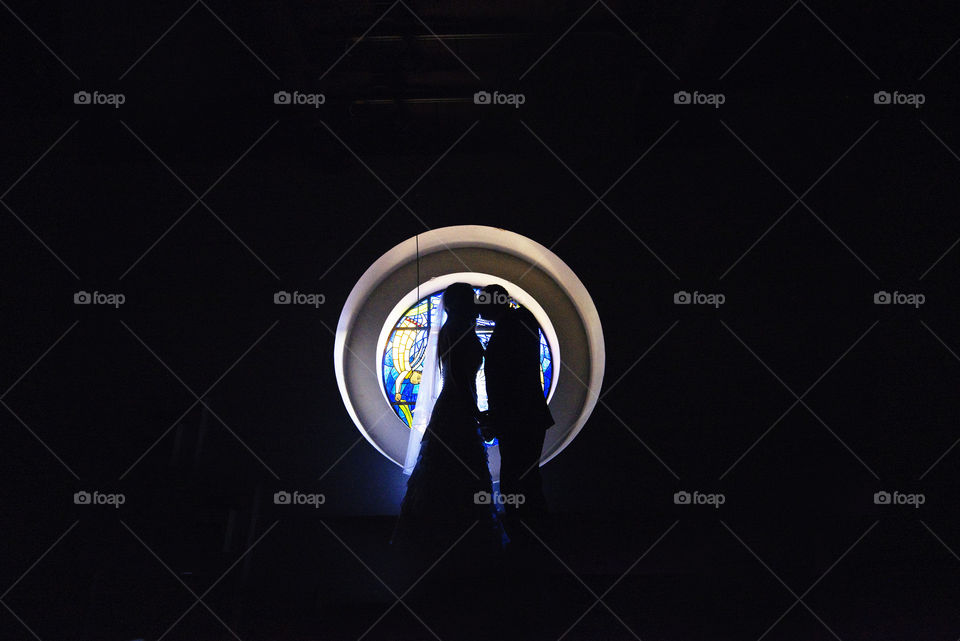 Couple silhouette kissing in colorful stainglass window
