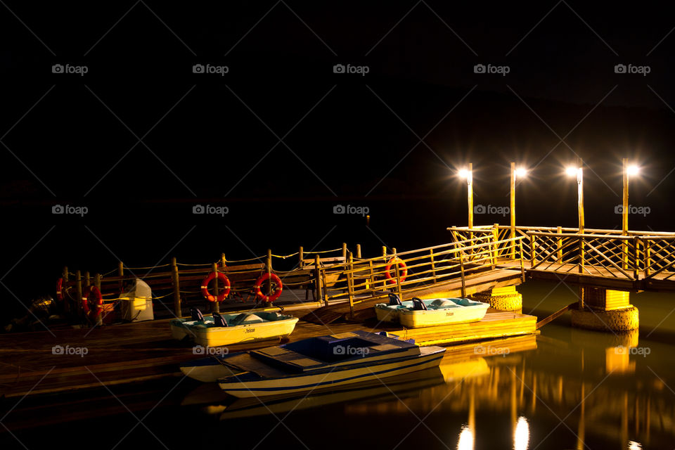 Long exposure image of a night scene of boats on a river with lights