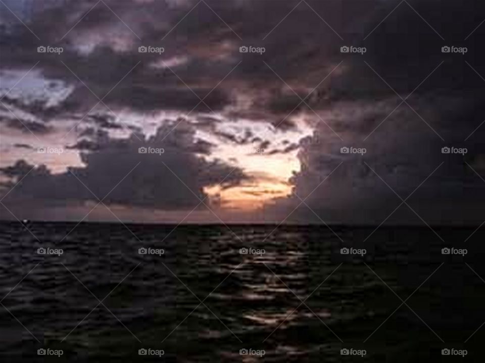 Sunset over the Gulf of Mexico, with thunderstorm in the distance.